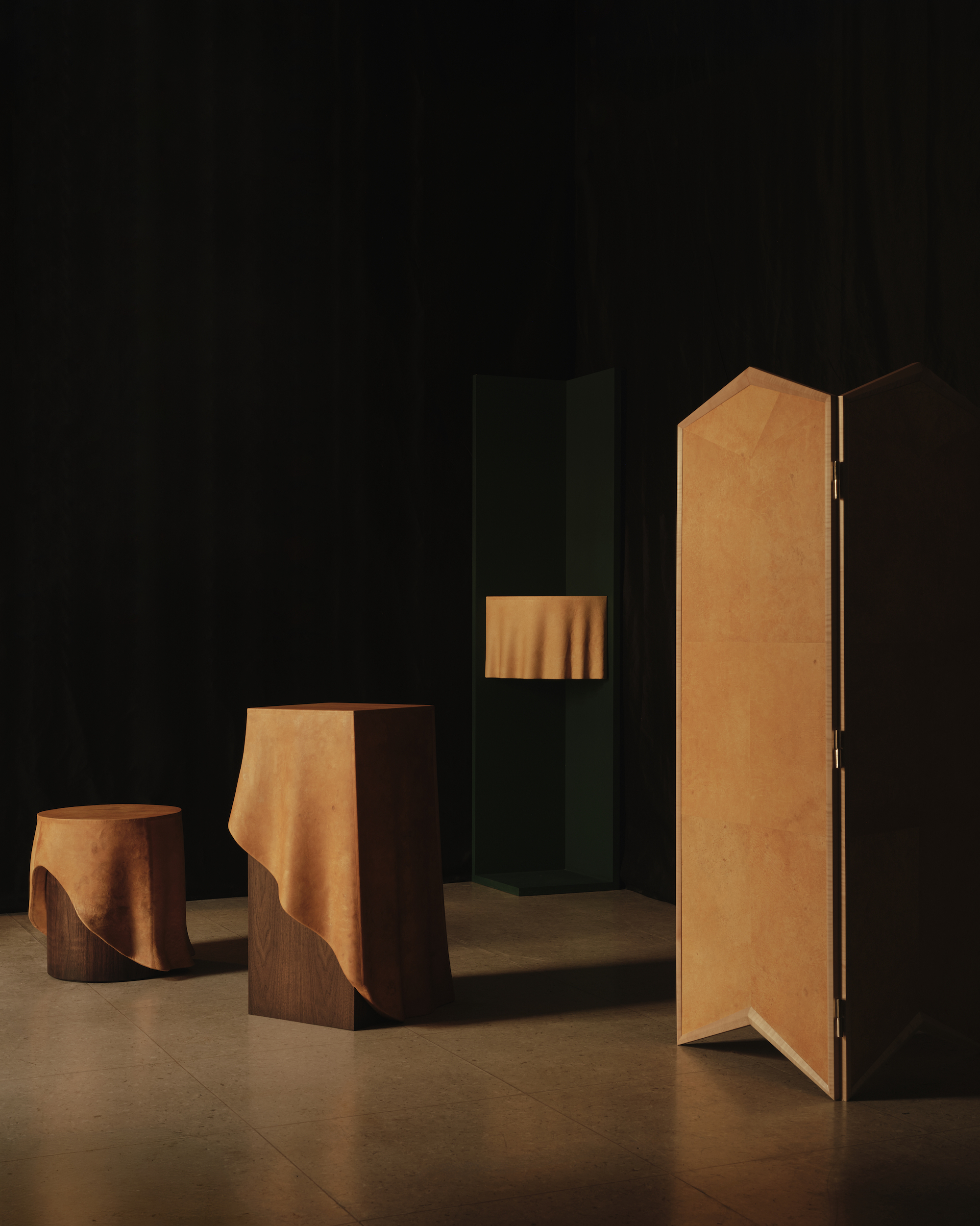 A series of sculptural furniture increasing in size from a small pedestal to a folding screen, all in a tan, beige colour.
