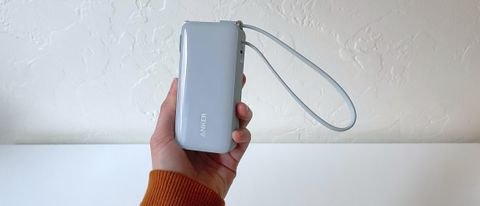 A hand holding the Anker A1637 portable charger in front of a white background