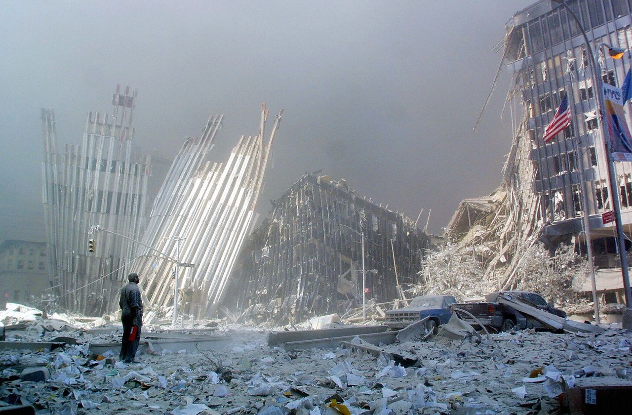 A man, standing amid the rubble of the World Trade Centers on Sept. 11, calls out, asking if anyone needs help.