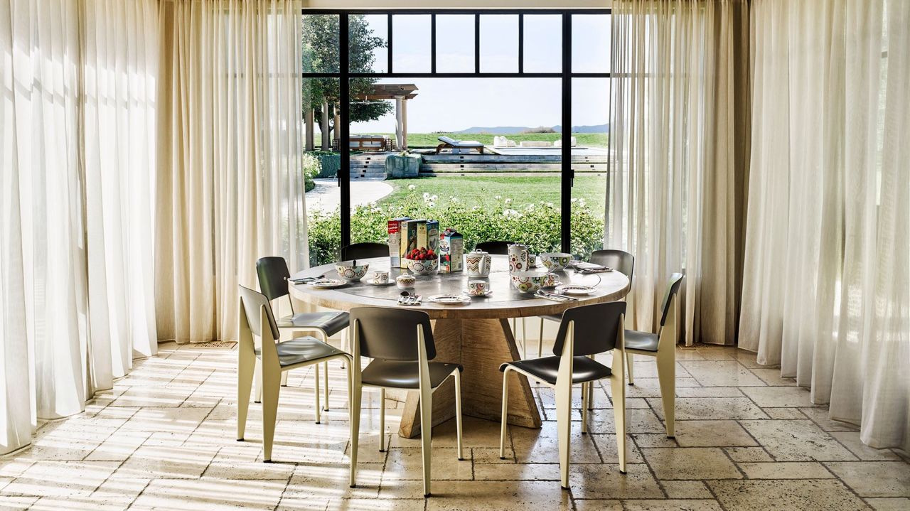 dining room with glass walls overlooking garden