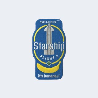 a blue spaceflight mission patch, showing a silver spacecraft above a yellow banana and the phrase "it's bananas!"