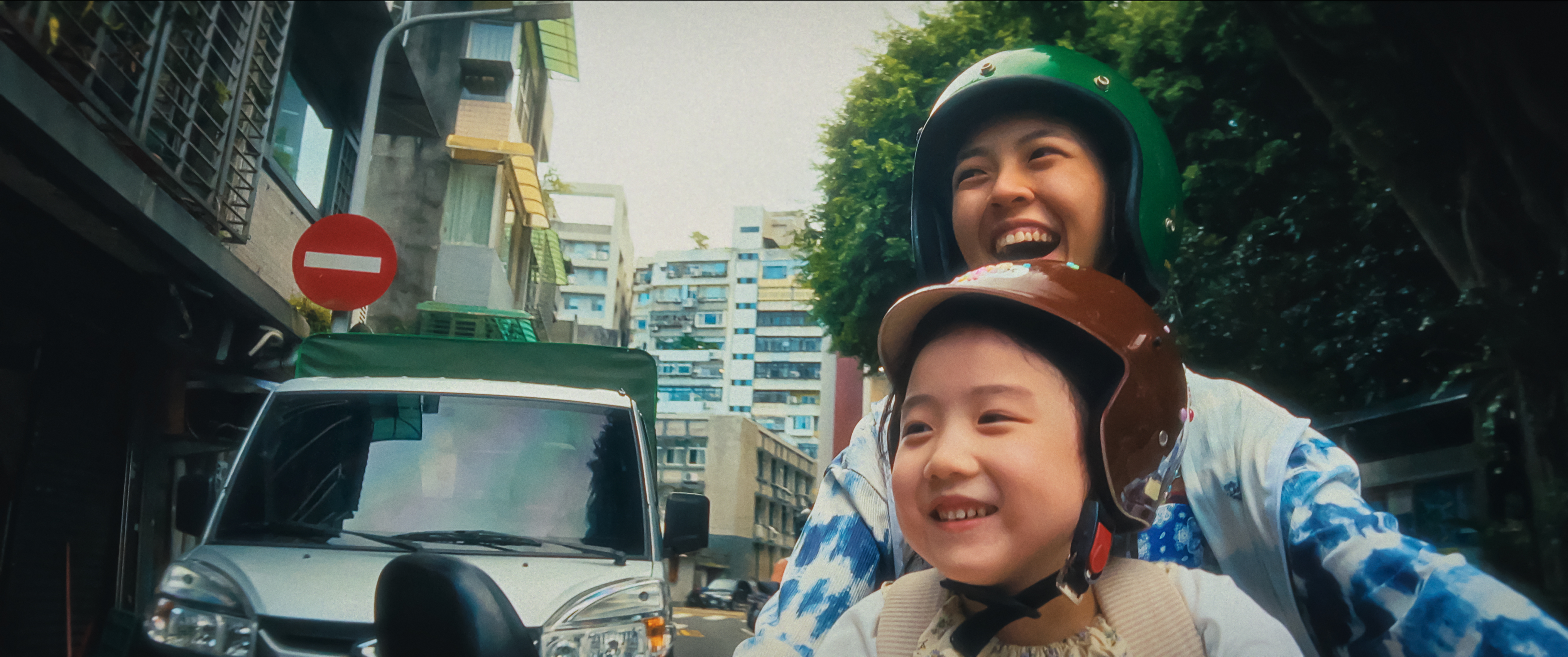 Young child and an adult riding in the street