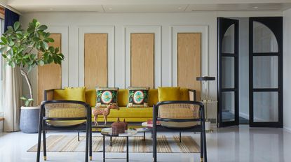 A living room with wall panels and a tall plant