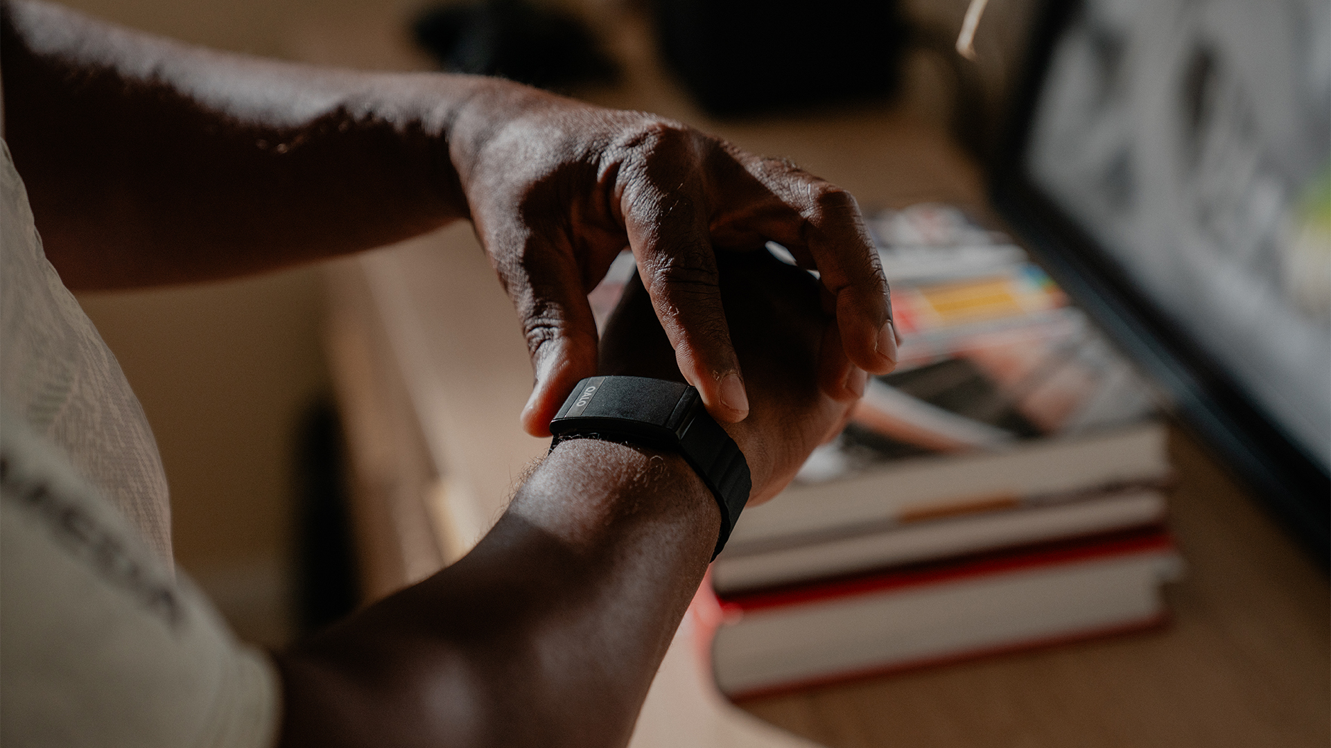 A close up of the QALO SL-1 smart band on a man's wrist