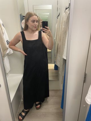 Woman in dressing room wearing black linen dress