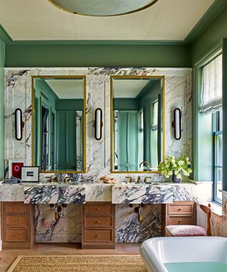 bathroom with green walls and marble and wood vanity