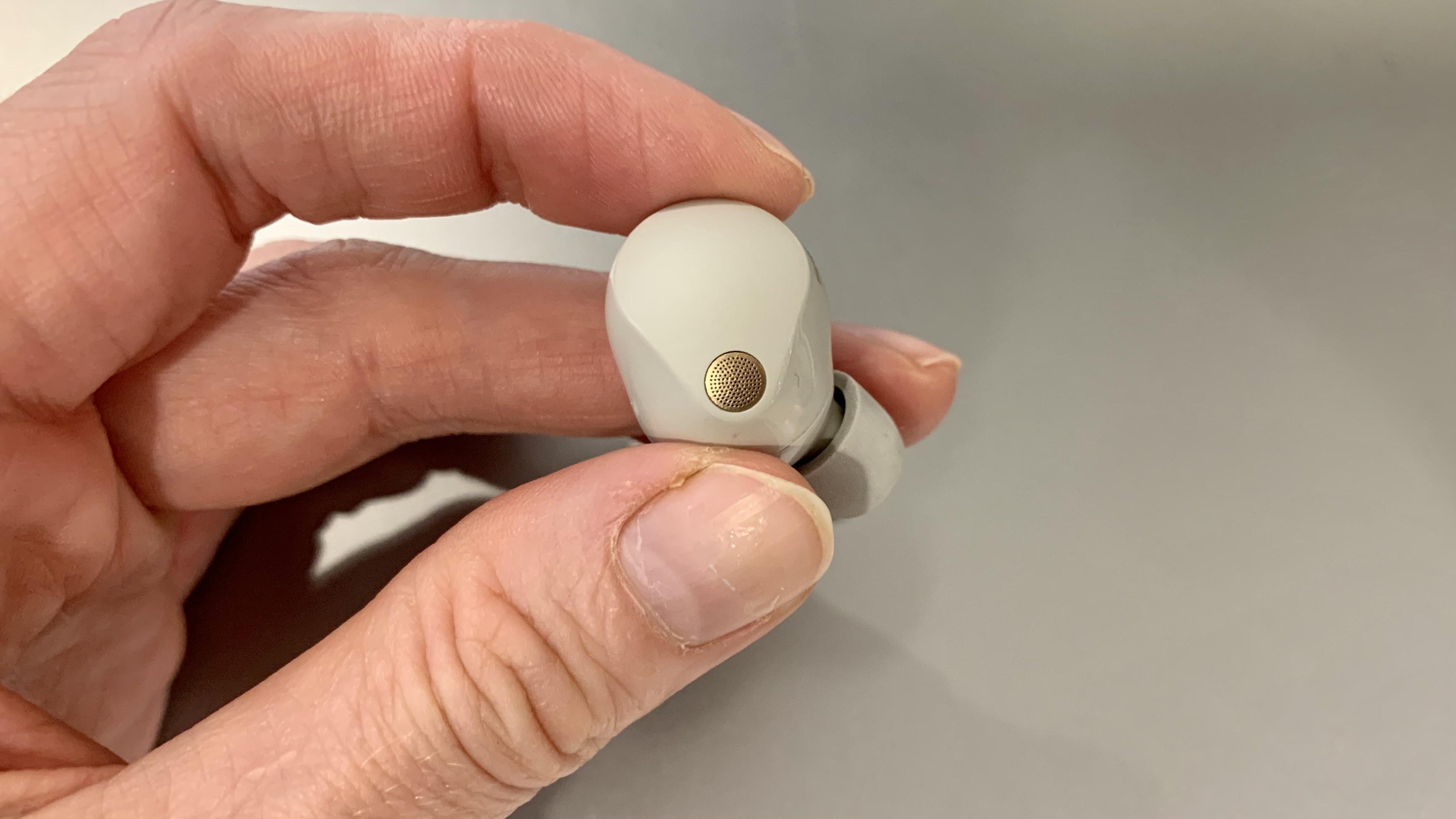 Sony WF-1000XM5 earbud held in a hand