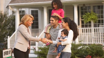 Realtor meeting young couple and their child at a house for sale