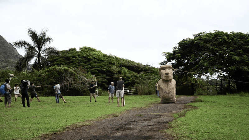 Researchers pulling ropes to make an Easter Island statues "walk"