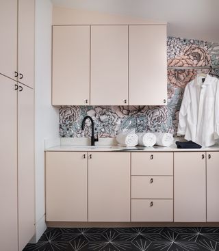 small laundry room ideas pink cabinets, printed wallpaper and hanging rail by Maestri Studio