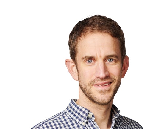 Portrait of Simon Richardson, Editor of Cycling Weekly UK, smiling in a checkered shirt.