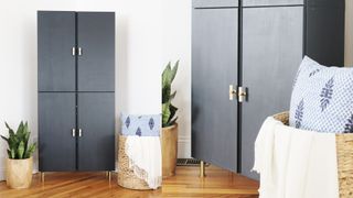 Dark blue freestanding cabinet with gold metal legs and handles