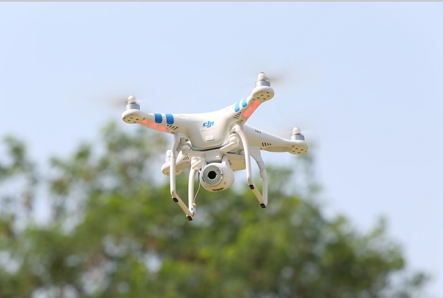 DJI Phantom 2 Vision drone flying in front of trees