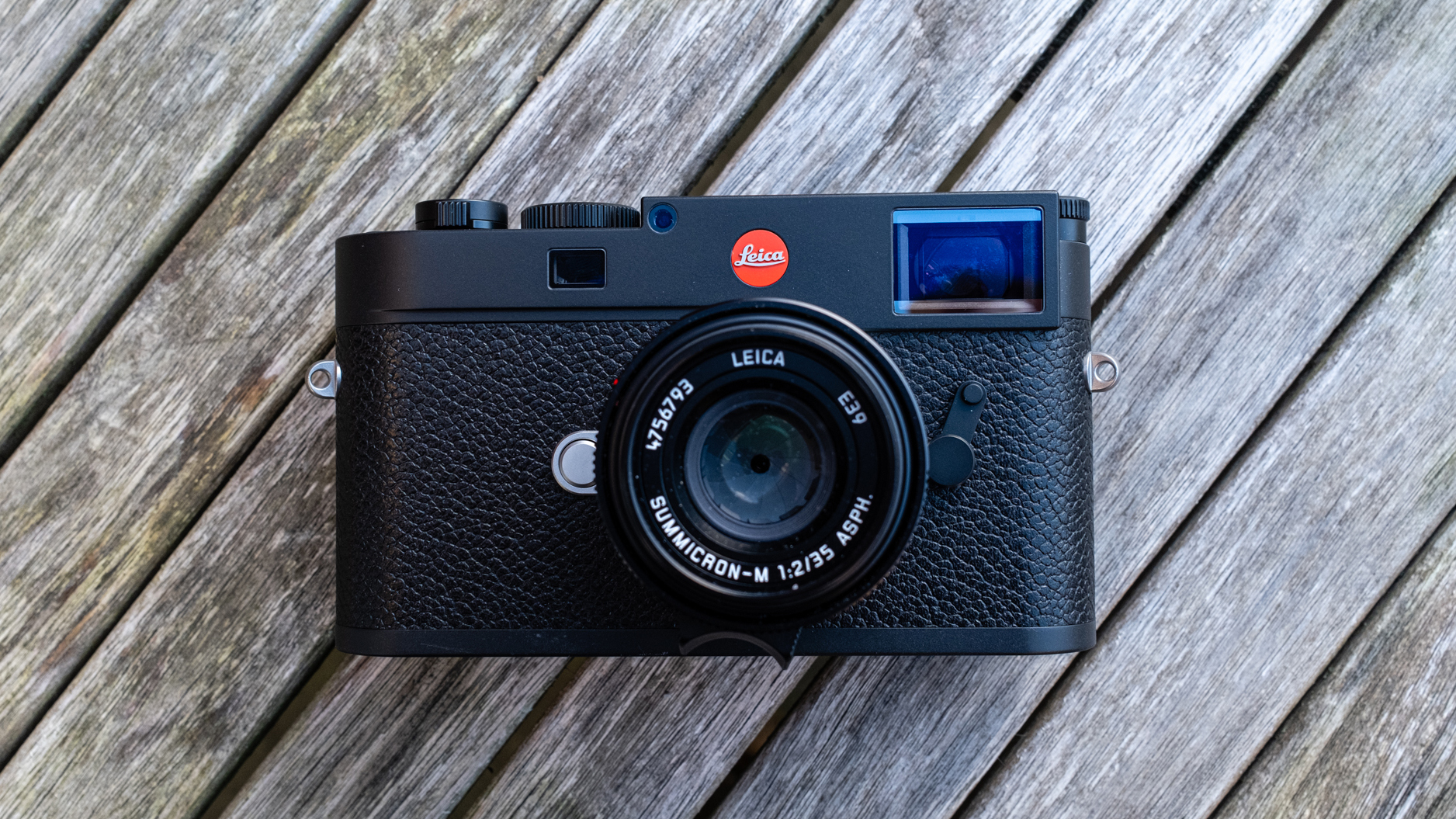 The Leica M11 camera resting on a wooden bench