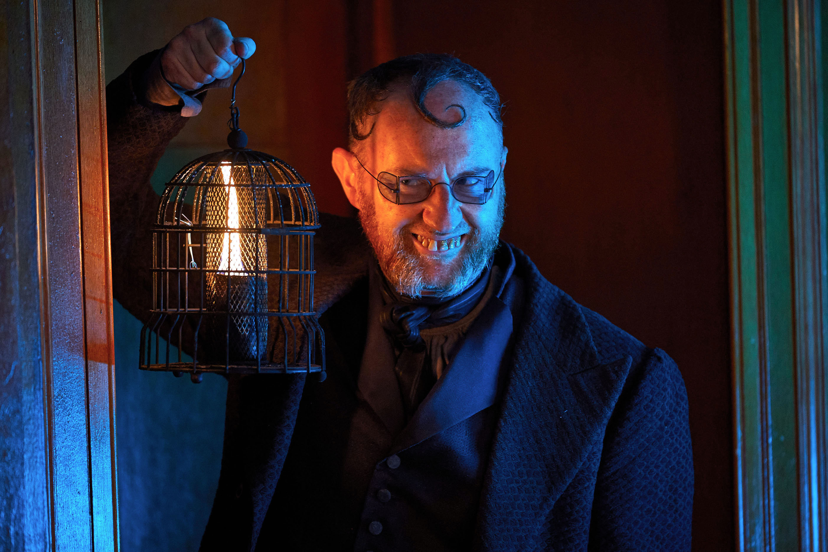 Mr Wickens (Mark Gatiss) appears in a doorway, bearing a candle aloft, a horrible smirk on his face and his yellow teeth on display