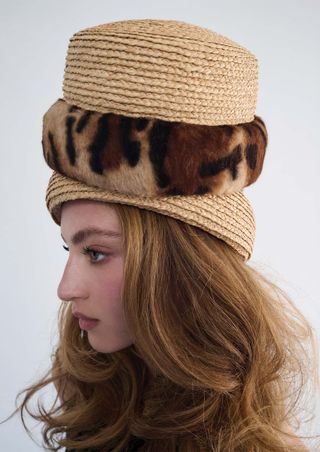 a model wears three pillbox hats stacked on top of each other in front of a plain backdrop