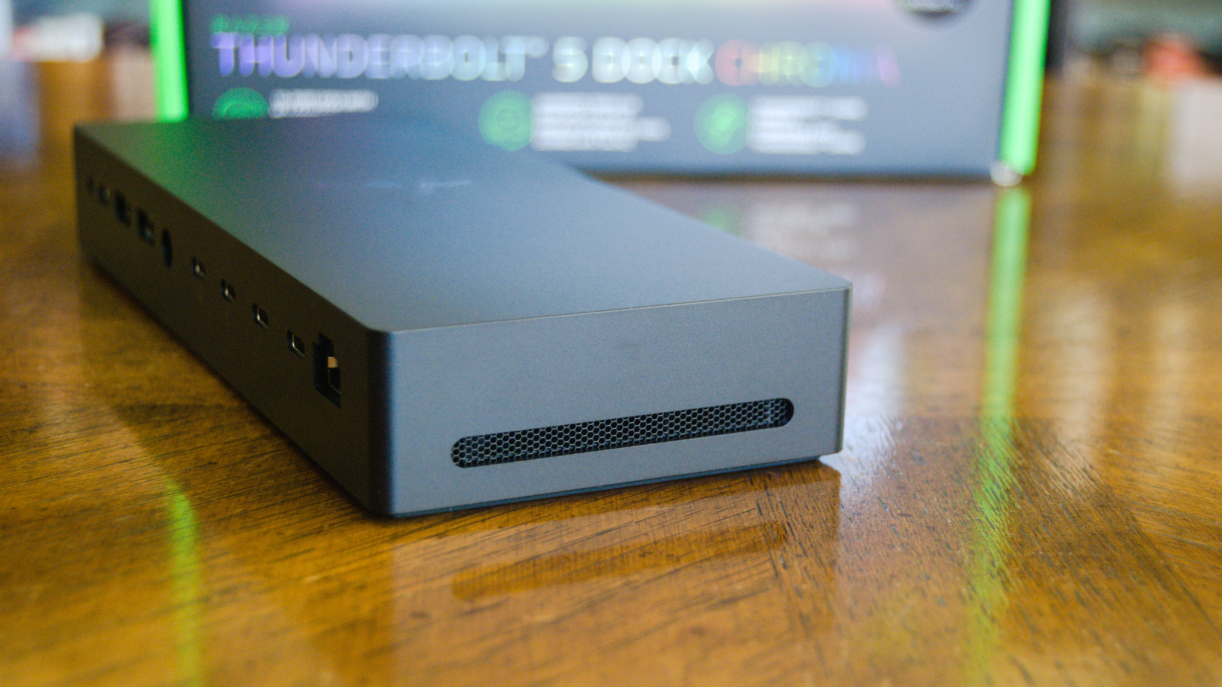 The Razer Thunderbolt 5 Dock Chroma sitting on a table with a side air vent in view.