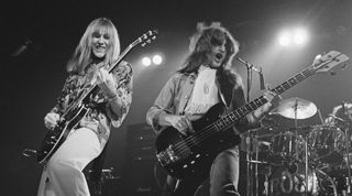 Alex Lifeson (left) and Geddy Lee performing with Canadian progressive rock group, Rush, at the Civic Center in Springfield, Massachusetts, during the band's All The World's a Stage tour, 9th December 1976. Neil Peart is on drums (right)