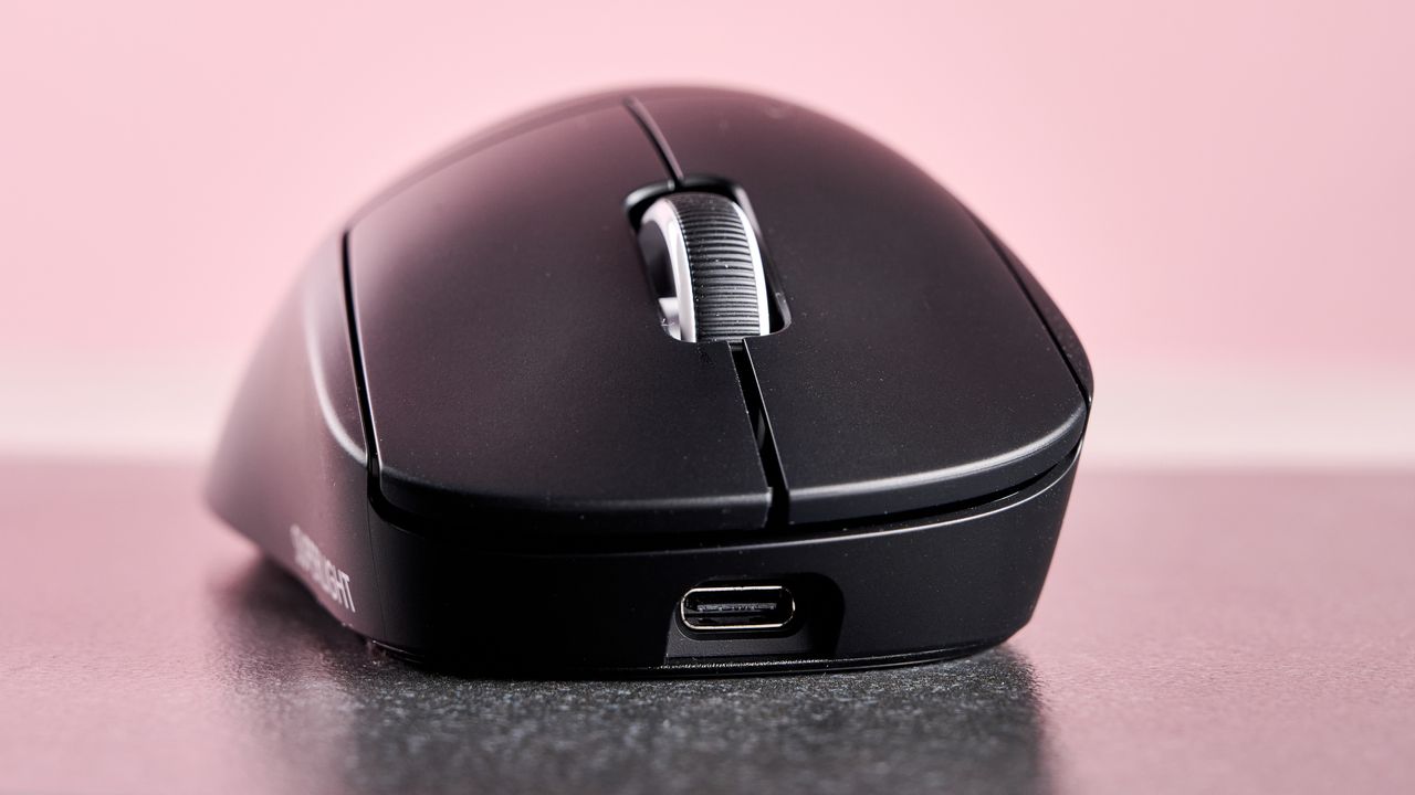 Close-up of front of Logitech Pro X Superlight 2 Dex, on table with pink background