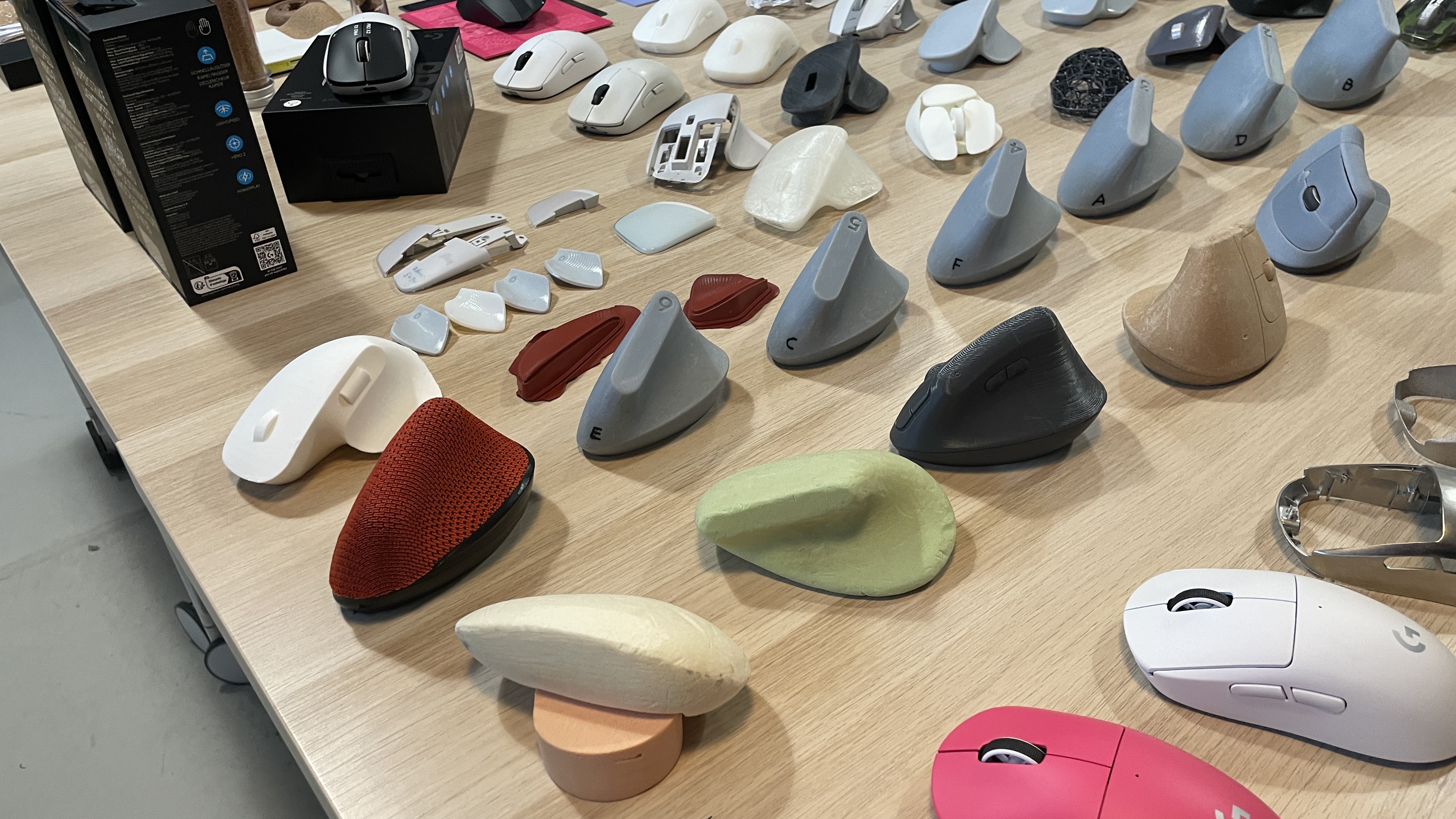 A range of Logitech mice, some fully designed and some mid-design and mid-production, on a big table.