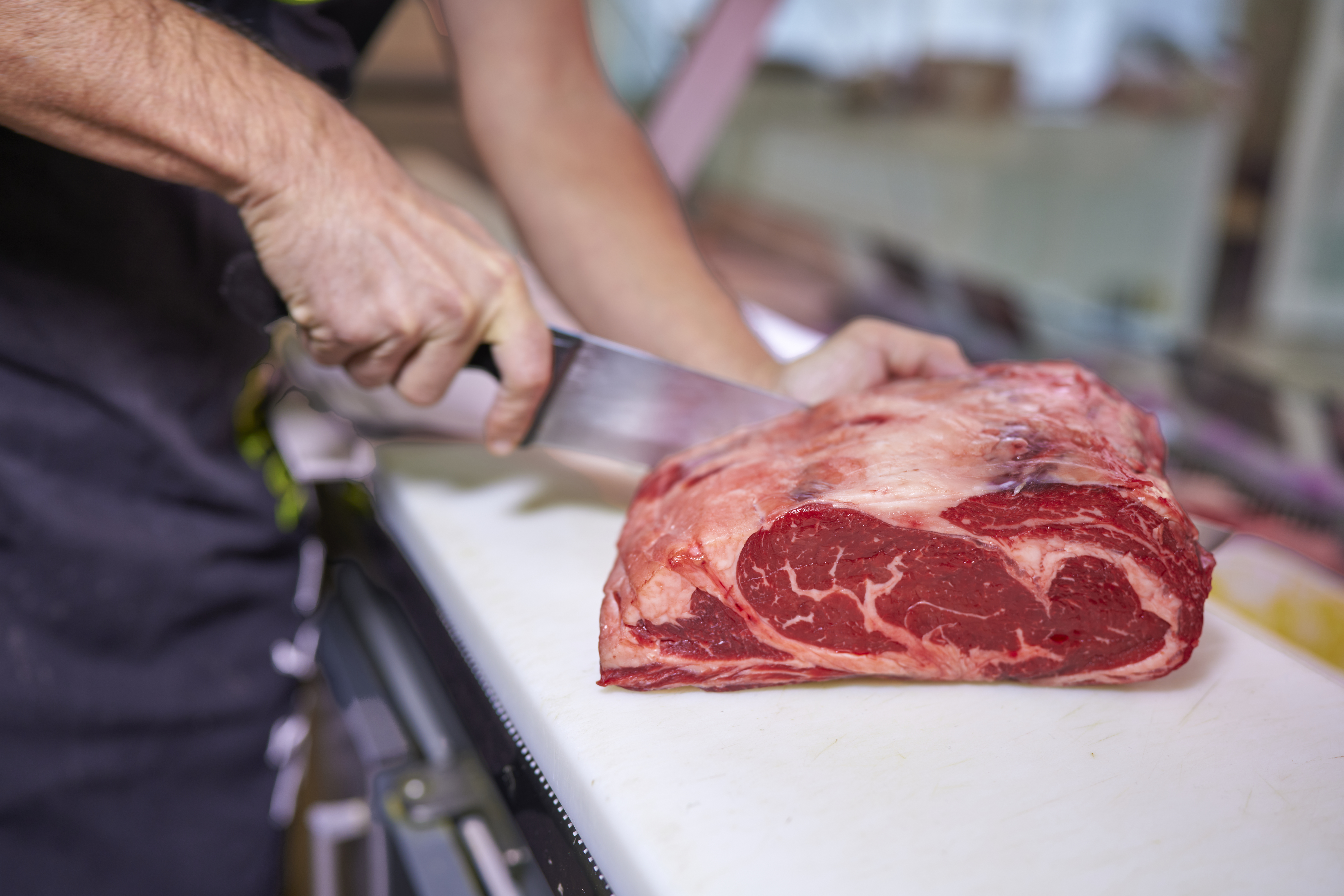 Butcher slicing sirloin steak