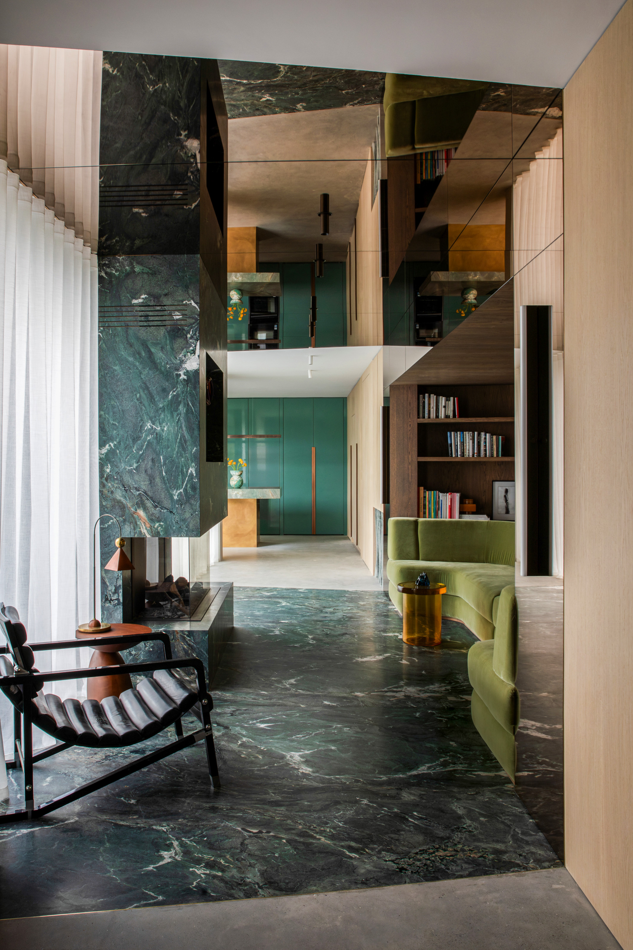 Transitional living room with marble floor and walls, mirrored ceiling and green curved velvet sofa