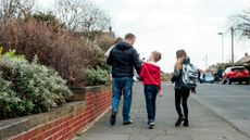 Three children walking down the road