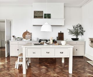 white kitchen island with legs and single drawers around the top