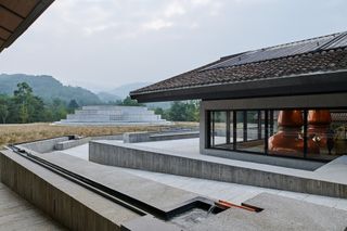Exterior view looking towards round building at the The Chuan malt whisky distillery by Neri and Hu