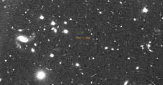 An image shows Farfarout, the most distant object ever spotted in the solar system, highlighted with red lines.