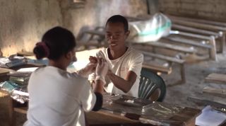 A medical worker in Madagascar provides help to a patient.