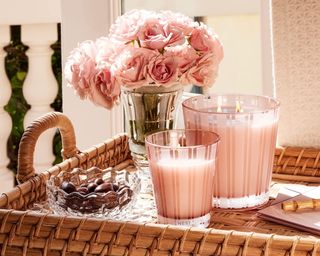 Nest New York pink candles sitting on side beside pink roses
