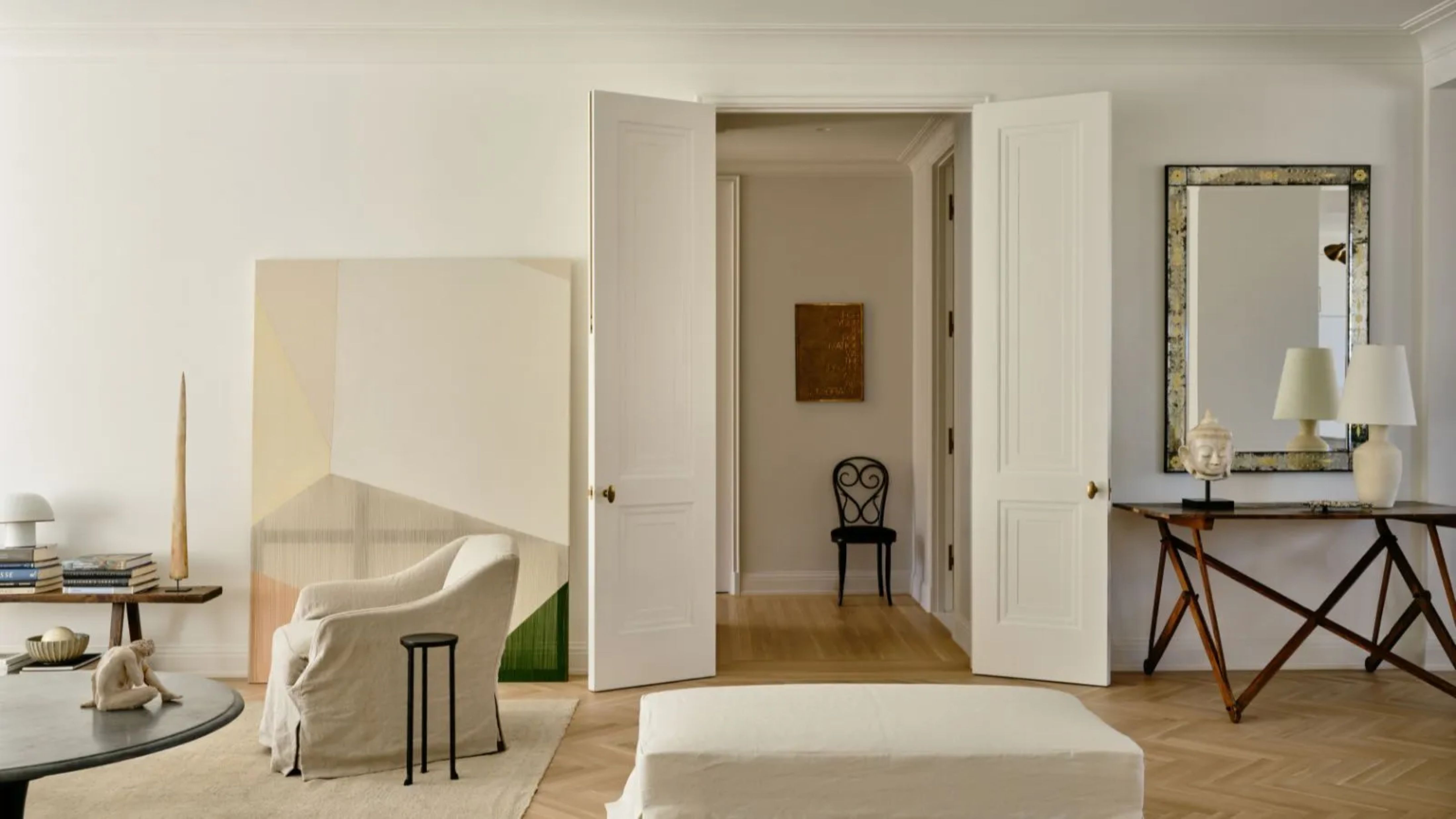 New York City living room demonstrating the principle of negative space in interior design using techniques such as slightly-too-small artwork and thoughtful gaps between large-scale furniture