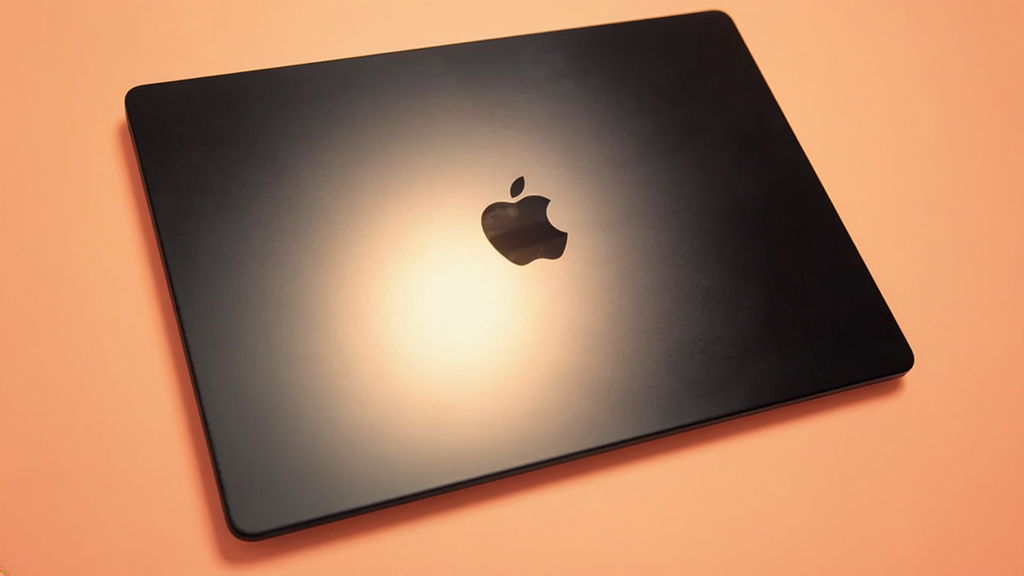 MacBook Pro M5 with orange background