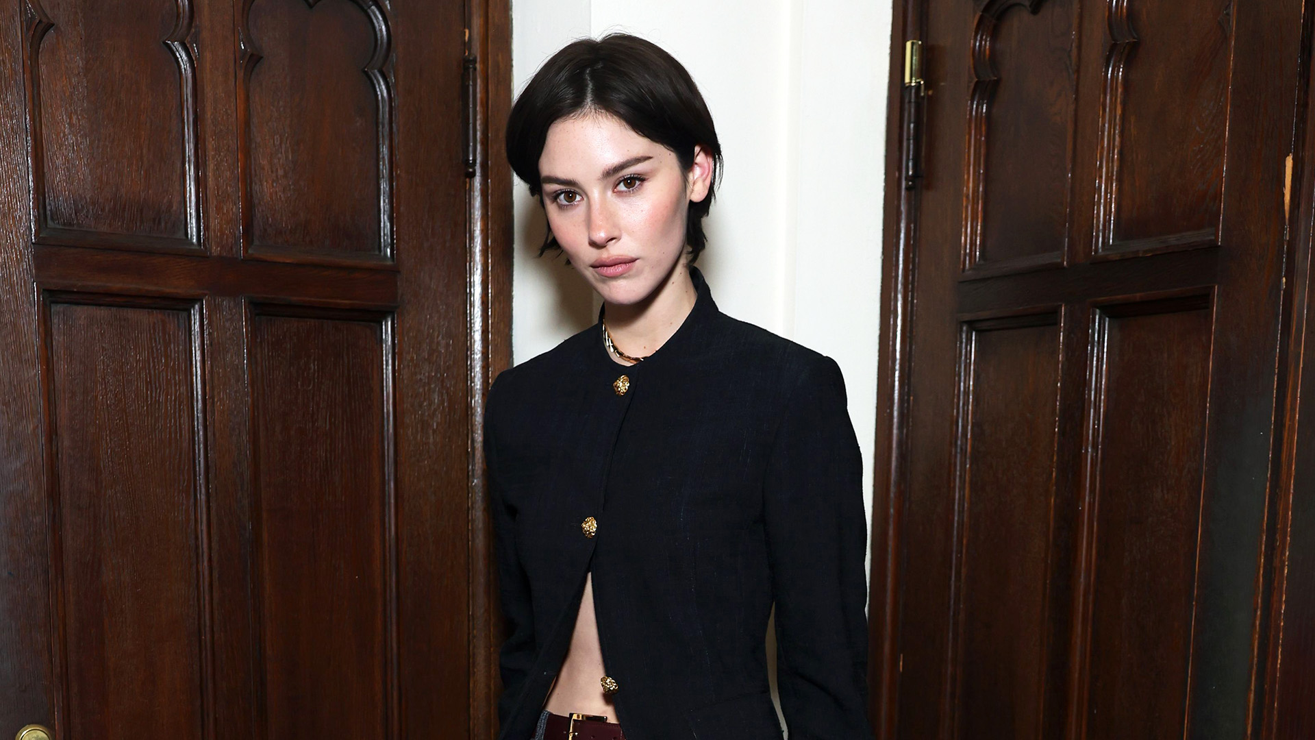 Gracie Abrams wearing a black blazer and gray trousers at the Coco Chanel event in Los Angeles