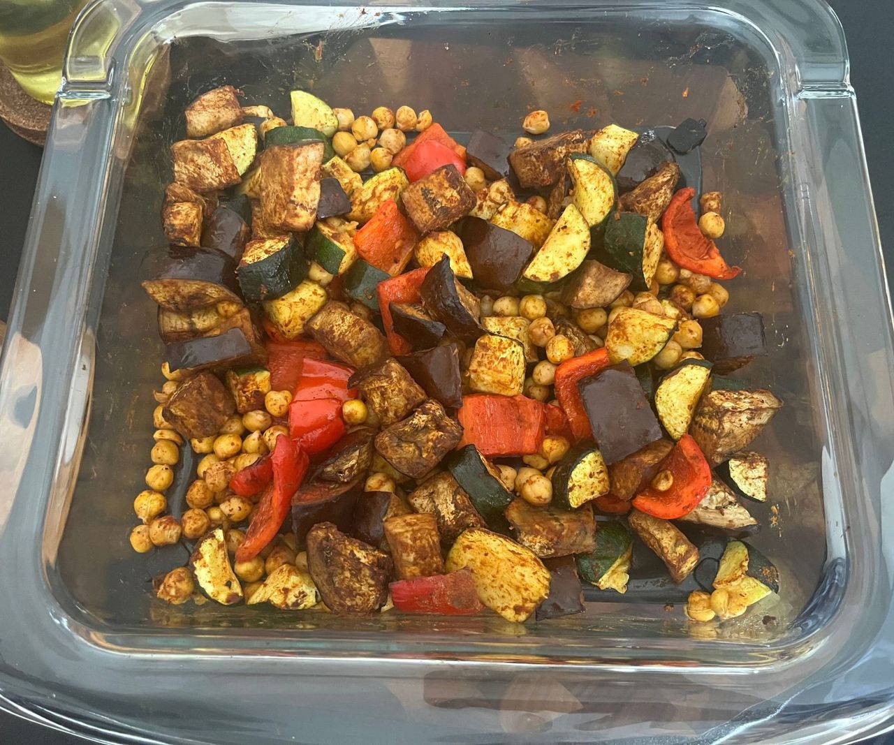 A glass air fryer dish with roasted vegetables inside