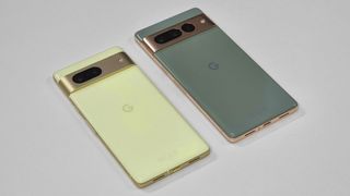 En gul Google Pixel 7 og en grå Google Pixel 7 Pro ligger ved siden av hverandre på et hvitt bord.