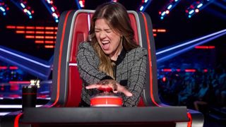 Kelly Clarkson is shown making an excited face as she pushes her button on The Voice Season 30.
