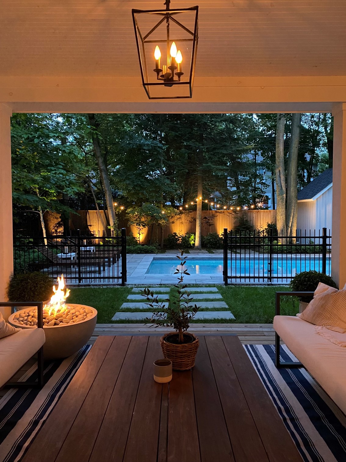 A back garden with fairy lights strung through the trees