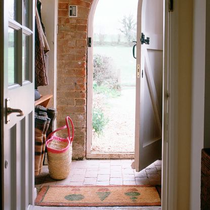 home with brick wall and open door