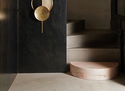 black entryway with pink marble first step and concrete stairs
