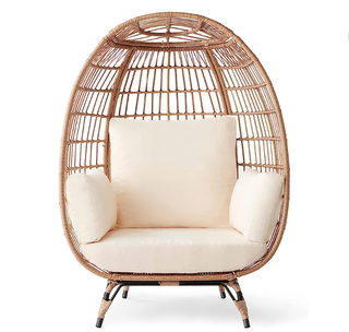 egg chair with light brown wicker casing and cream pillows