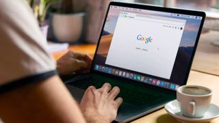 person at desk on laptop accessing google