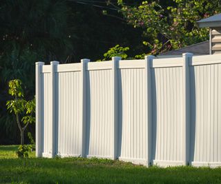 A white vinyl fence in a backyard