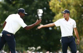 Sahith Theegala and Collin Morikawa high five after holing a putt