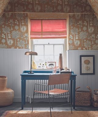 Home office in attic room with orange wallpaper