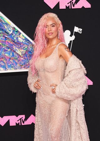 Artist Karol G wearing sheer dress and pink hair on the MTV VMAs 2023 Red Carpet