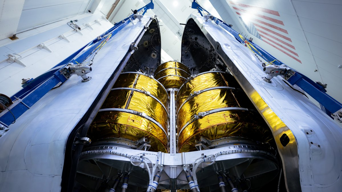 A stack of five gold-wrapped AST SpaceMobile satellites stacked for launch between their SpaceX Falcon 9 rocket nosecone.