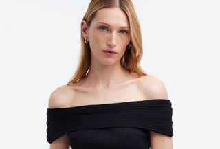 Woman wearing off-the-shoulder black Madewell top.