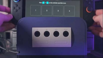 Retro Fighters GameCube Battle Dock with hands lowering Switch 2 onto docking station.